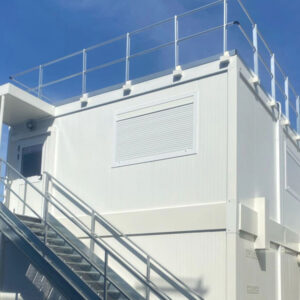 RÉALISATION : Pose d’un bâtiment préfabriqué en R+1 avec garde-corps et échelle crinoline, installation électrique, réseau informatique et climatisation.